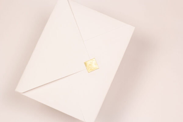 Convite casamento clássico moderno com envelope tradicional branco, letras douradas e lacre de cera.