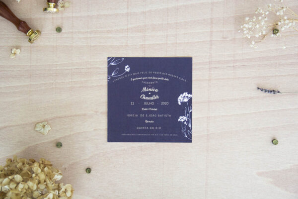 O convite para casamento simples "Compton" contém fundo de cor com apontamentos florais. Fecha com papel translúcido e com faixa impressa ou cordel.